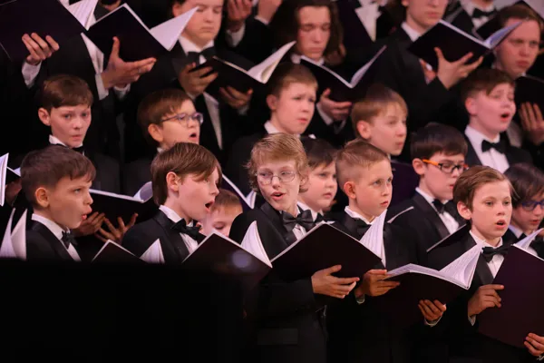 На сцене Рахманиновского зала Хор мальчиков и Мужской хор учащихся и студентов АХИ имени В.С. Попова